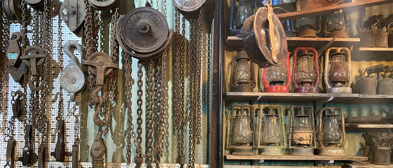 Chain blocks, pulleys and a shelf of kerosene lanterns on the shop wall