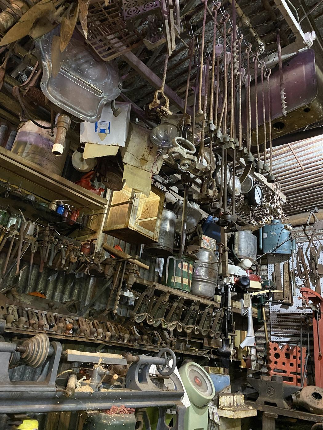 Augers, headlamps, a copper bath and milk cans hanging from the shed roof