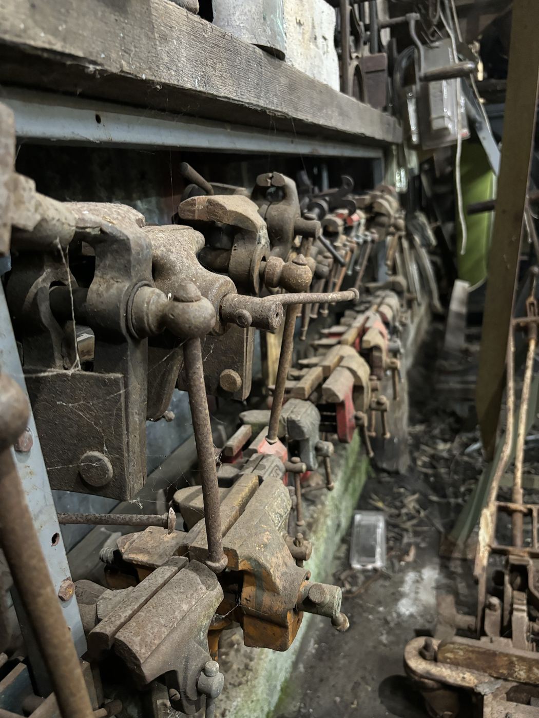 A row of bench vices bolted along a rail
